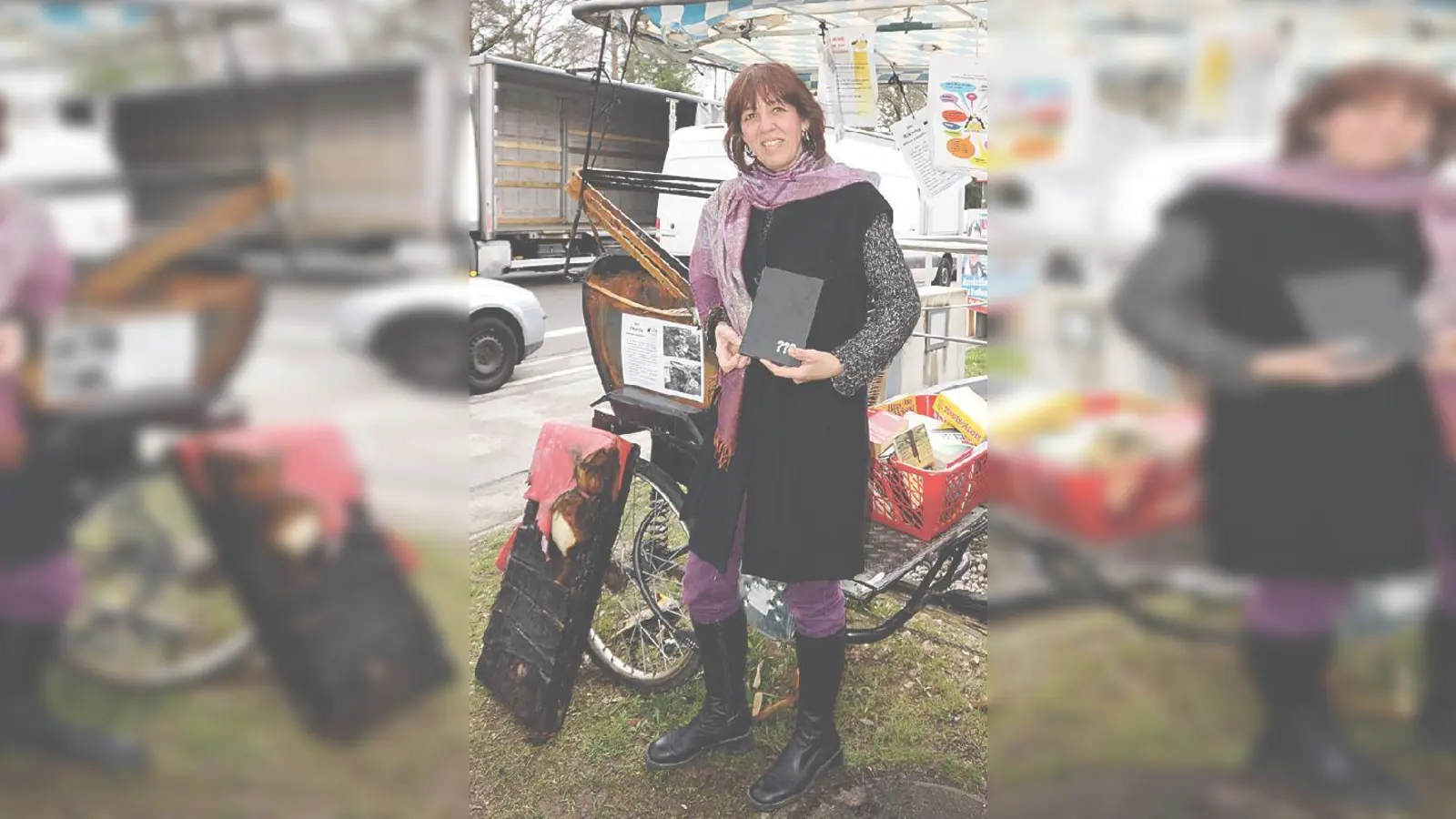 Christine Gruzlewski neben der angekokelten Bücher-Rikscha am Waldheimplatz. 	 (Foto: Boschert)