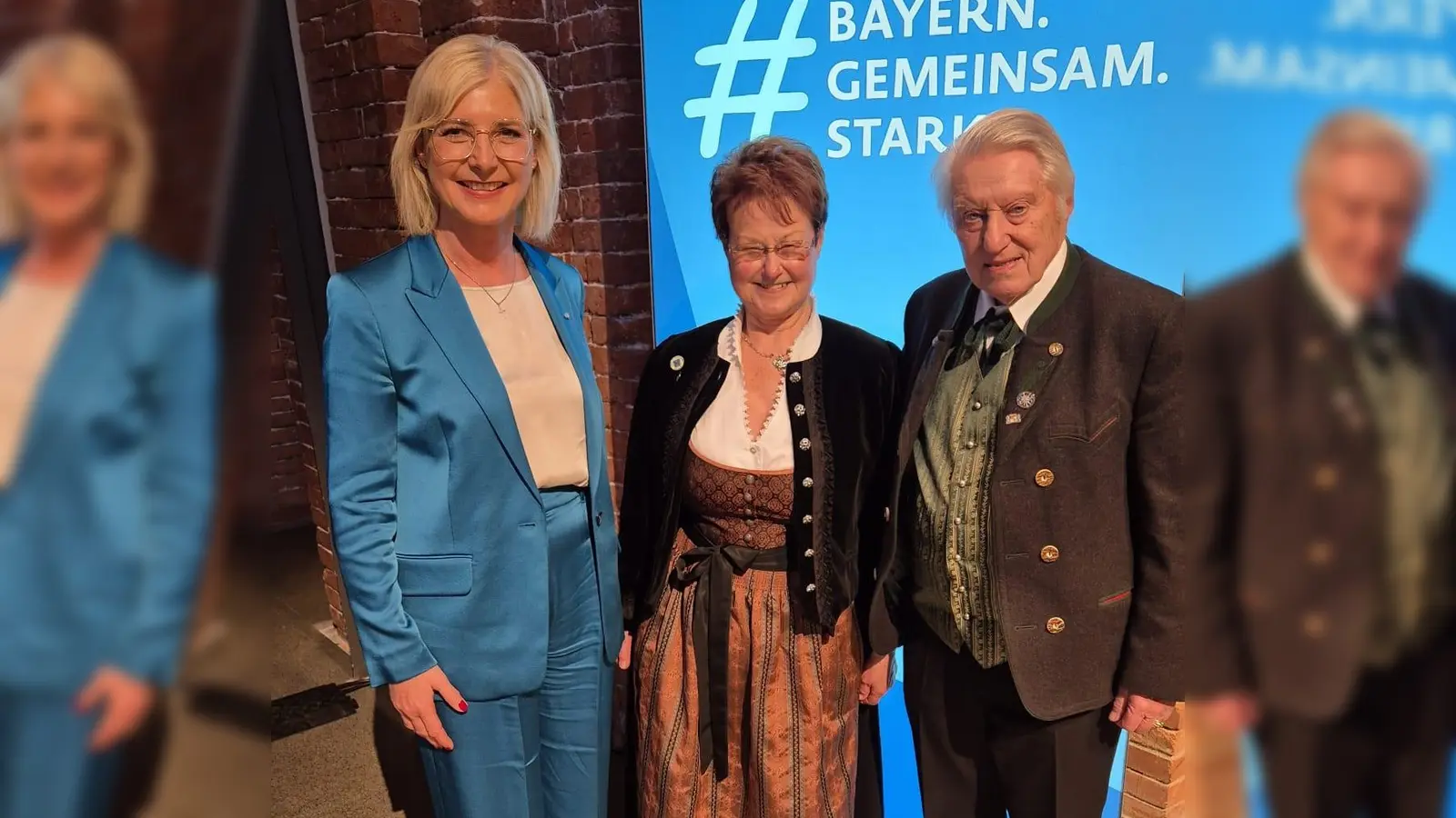 Freude bei der Ehrung (v.l.): Ulrike Scharf (Staatsministerin für Familie, Arbeit und Soziales) mit Karin Wolf und deren Ehemann. (Foto: Gemeinde Krailling)