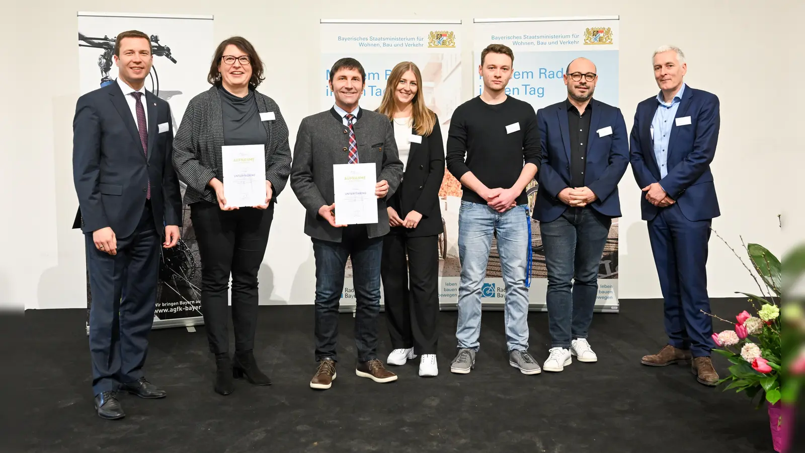 Unterföhrings Bürgermeister Andreas Kemmelmeyer (3.v.l.) und Mobilitätsmanagerin Caroline Borus (4.v.l.) erhielten von Ministerialdirektor Thomas Gruber (r.) und Matthias Dießl (l.), Vorsitzender der AGFK Bayern, die Aufnahmeurkunde als AGFK-Mitglied. (Foto: AGFK Bayern/Tobias Hase)
