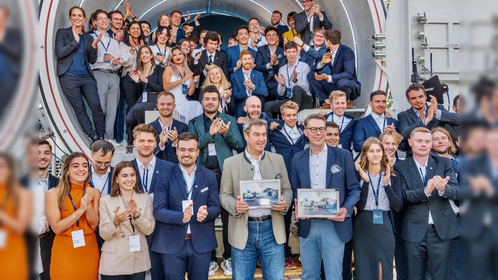 Ministerpräsident Markus Söder und Wissenschaftsminister Markus Blume mit dem Hyperloop-Team vor dem Testsegment, das jetzt in Ottobrunn der Öffentlichkeit präsentiert wurde. (Foto: StMWK/Wolfgang M. Weber)