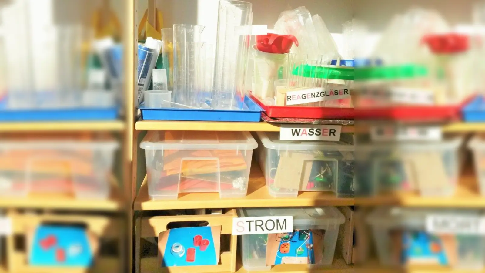 In einem Gruppenraum des Kindergartens „Regenbogen” stehen in Regalen viele Kisten, in denen sich Utensilien für die verschiedensten Experimente befinden. (Foto: jb)