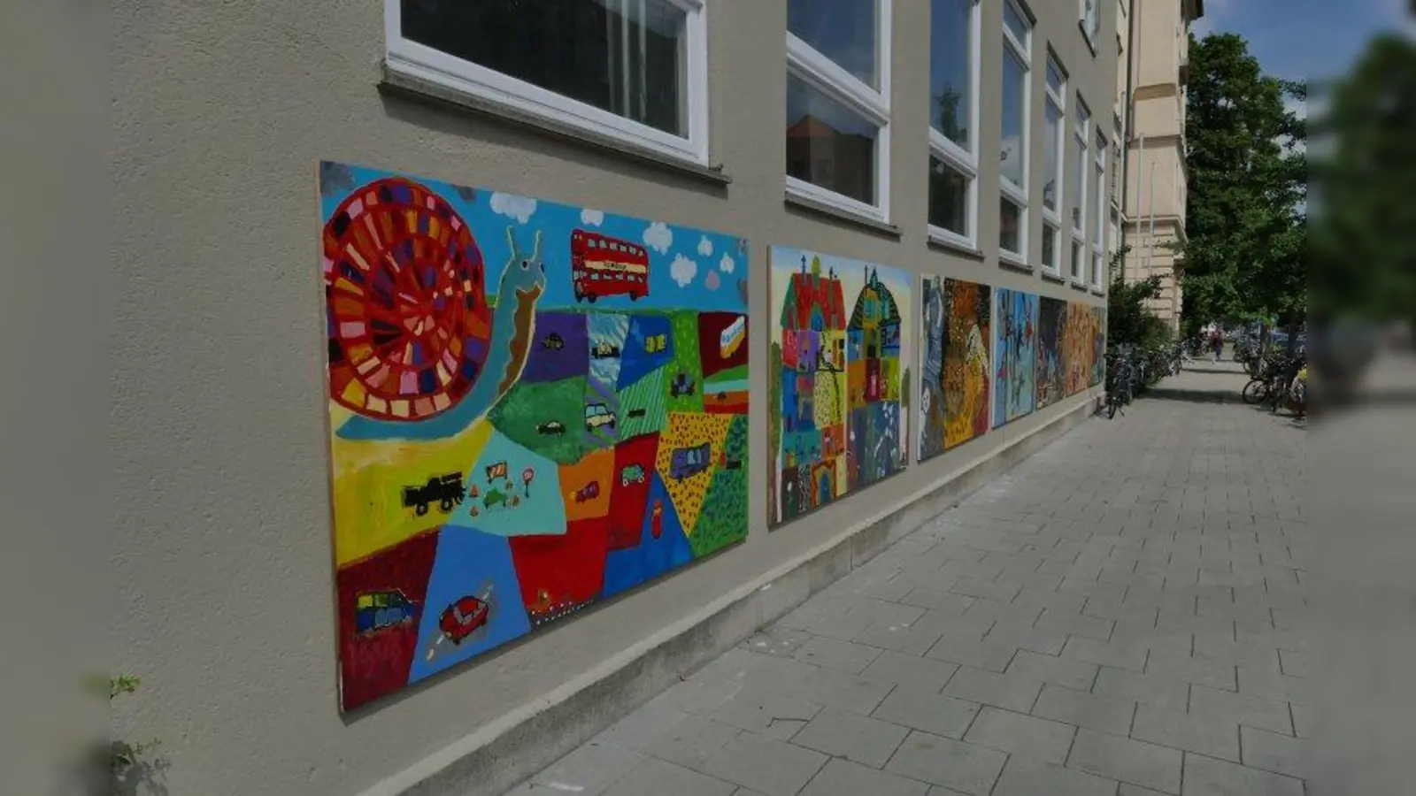 Die Gemälde, die zur Zeit noch an der Außenmauer der Turnhalle hängen, sollen die Flure der Bergmannschule zieren. (Foto: ds)