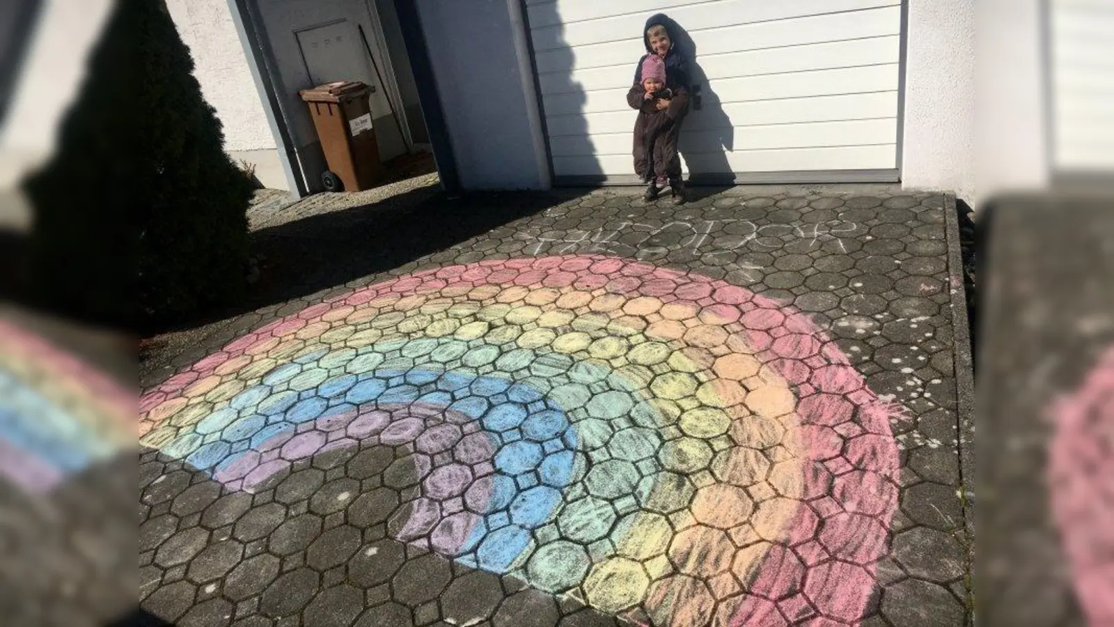 Theodor (5), Ludwig (4) und Cecilia (1) haben  fleißig gemalt und mit diesem Regenbogen in ihrem Vorgarten in der Hadern ein Zeichen gesetzt. „Unsere Kinder finden die Regenbogenaktion ganz toll”, schreiben ihre Eltern. „Natürlich hoffen sie aber auch sehr, dass sie sich bald wieder mit ihren Freunden treffen können und mit uns Eltern in den Urlaub fahren können.” (Foto: pr)