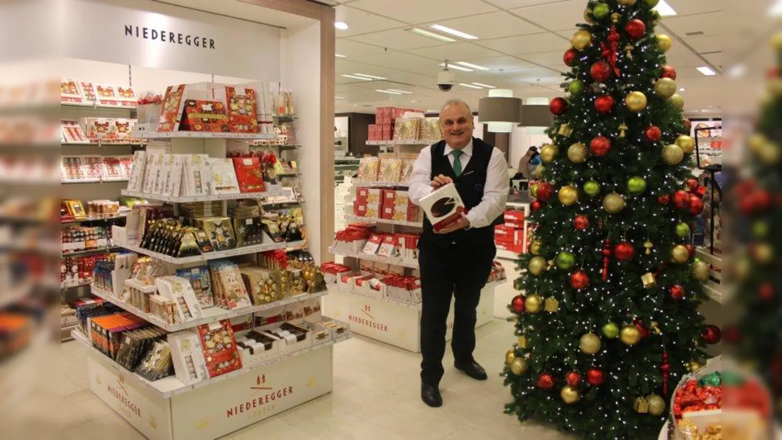 Harald Sander, Leiter der Lebensmittelabteilung der Galeria Kaufhof am Rotkreuzplatz, zeigt die Niederegger Marzipan-Torte, die Kunden am 1. und 2. Dezember mit einer individuellen Grußbotschaft beschriften lassen können. (Foto: sb)