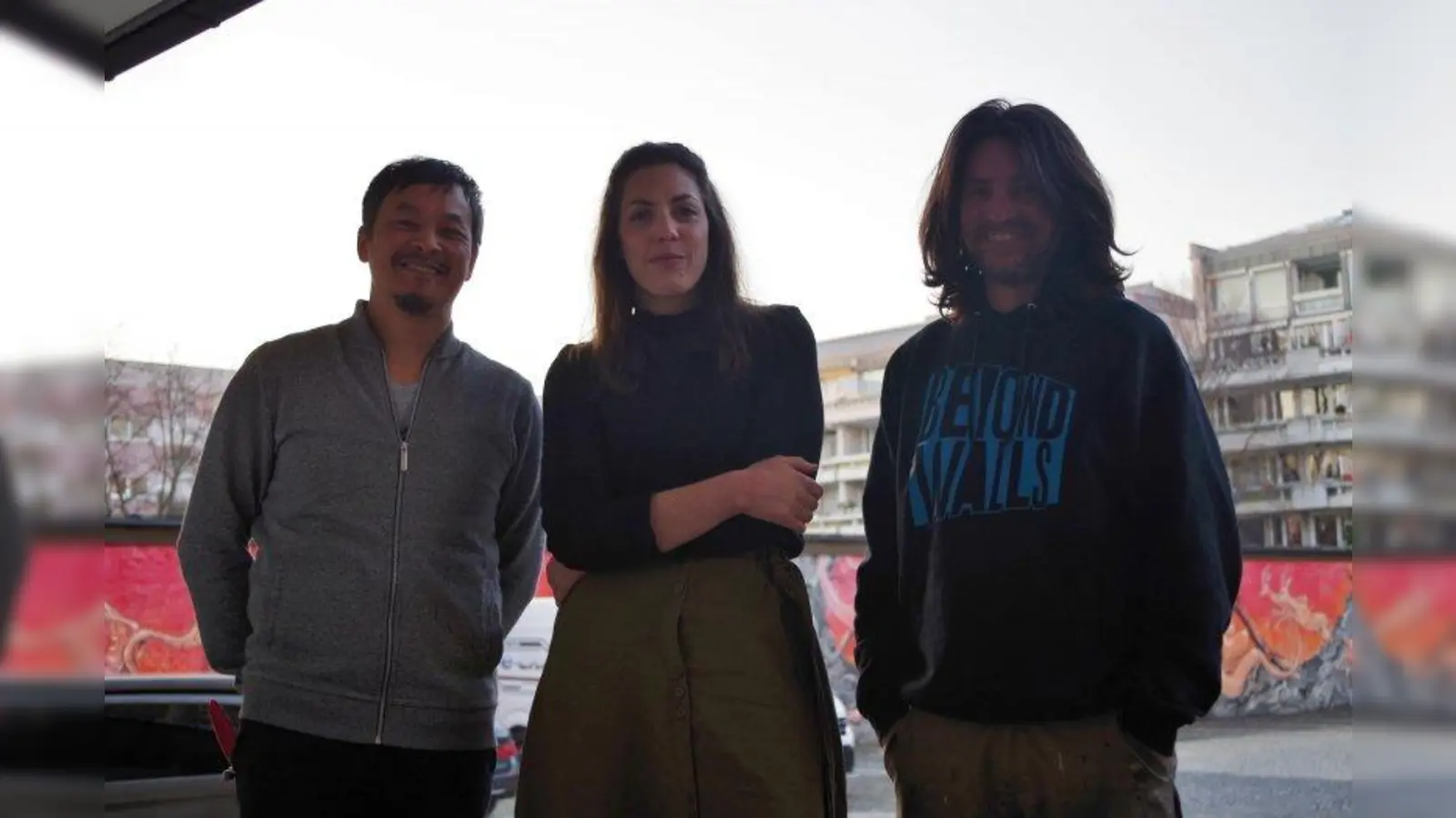 Die drei Kuratoren für das Kunstprojekt „Z common groung“ in der Zschokkestraße 36 sind (von links): Künstler Daniel Man, Kunsthistorikerin Laura Lang und Street-Art-Künstler Loomit. Das Graffiti auf der Wand im Hintergrund stammt von Video Oner und Sckre. (Foto: kö)