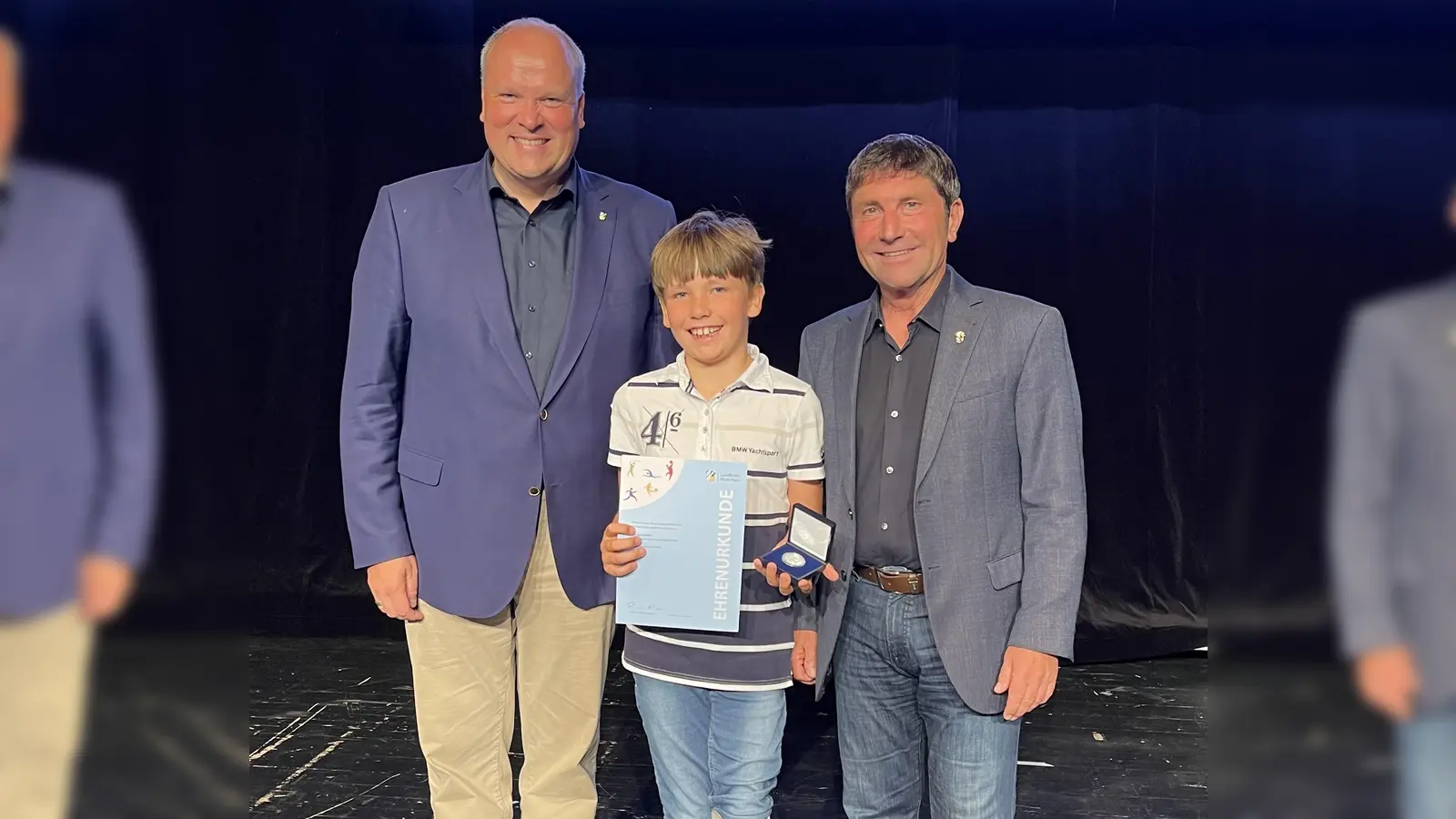 Nico Schimanski aus Unterföhring wurde für seinen Deutschen Meister im Para-Karte AK 8 geehrt. Ihm gratulierten Landrat Christoph Göbel (l.) und Bürgermeister Andreas Kemmelmeyer (r.). (Foto: hw)