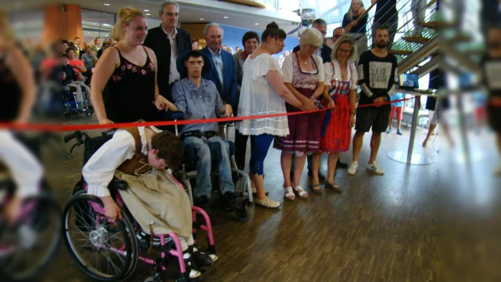 Gemeinsam durchtrennten Bewohner, Eltern, Betreuer und Politiker das rote Band, das zum renovierten Gebäudetrakt führte. (Foto: pst)