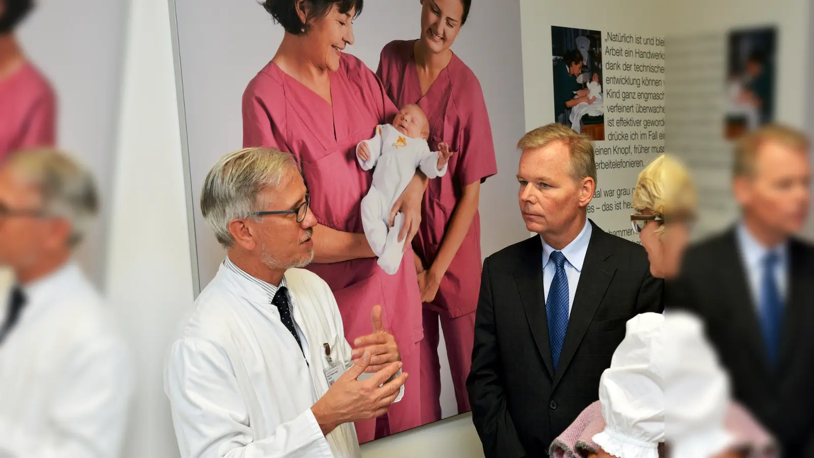 Der Bürgermeister der Gemeinde Grünwald Jan Neusiedl (Mitte) mit Prof. Marcus Krüger (links), Chefarzt der Klinik für Neonatologie Harlaching&Schwabing bei der Ausstellungseröffnung zu 50 Jahre Kindermedizin in Harlaching. (Foto: VA)