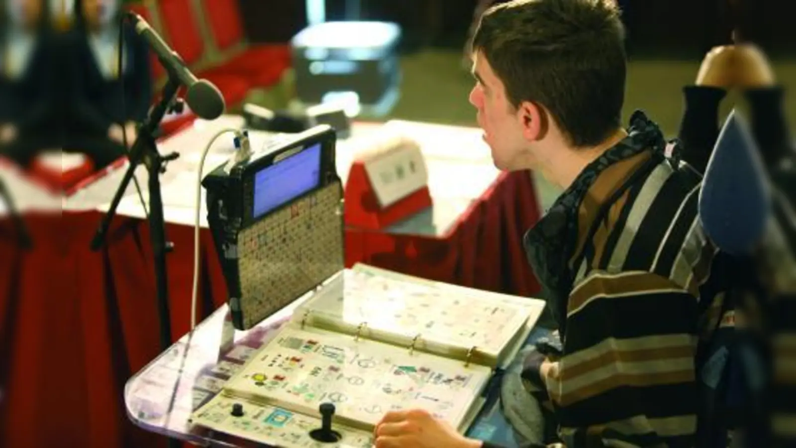 Referenten in eigener Sache: „Ich höre nicht gerne, wenn jemand sagt, dass ich nicht sprechen kann. Ich kann sprechen, aber auf andere Weise.“  Der schwer mehrfach körperbehindert Jens Ehler während seines Vortrags auf der interdisziplinären Tagung der Stiftung Leben pur. Der 22-Jährige kommuniziert mit Hilfe eines Sprachcomputers. (Foto: Michael McKee)