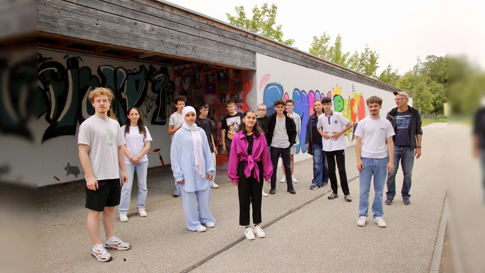 Die Graffiti-Künstler und ihre Unterstützer an der Campus-Bushaltestelle: Lukas Sterzenbach (links), Peter Hein, Raphael Merget (von rechts) sowie Bea Jung (4. von rechts).  (Foto: us)