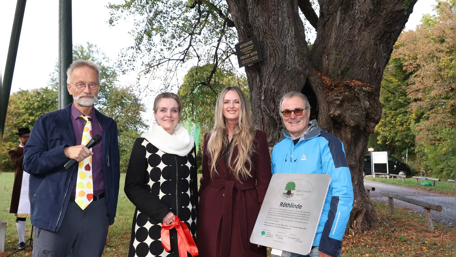Ein 450 Jahre altes, lebendes Denkmal: Andreas Roloff überreicht Jeanne-Marie Ehbauer, Mona Fuchs und Boris Schwartz die Urkunde für die Röthlinde als Nationalerbe-Baum Deutschlands. (Foto: Michael Nagy/ Presseamt LHM)