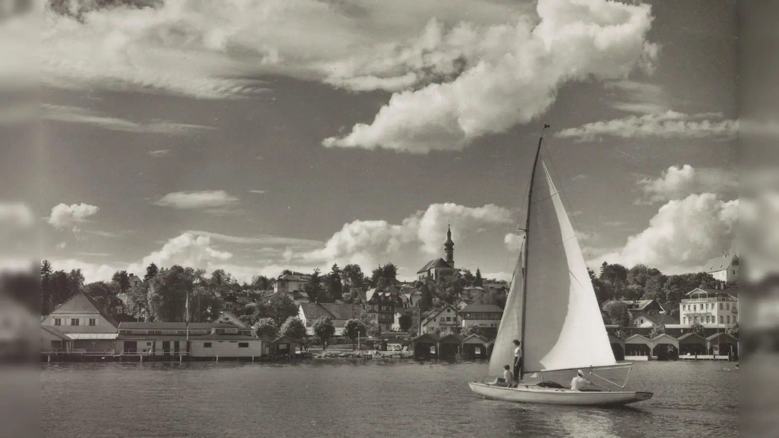 Das diesjährige Titelbild des Historischen Kalenders Starnberg zeigt eine gemütliche Segelpartie vor der Seepromenade und den mittlerweile abgerissenen Badehütten des Undosabades. (Foto: © Stadtarchiv Starnberg)