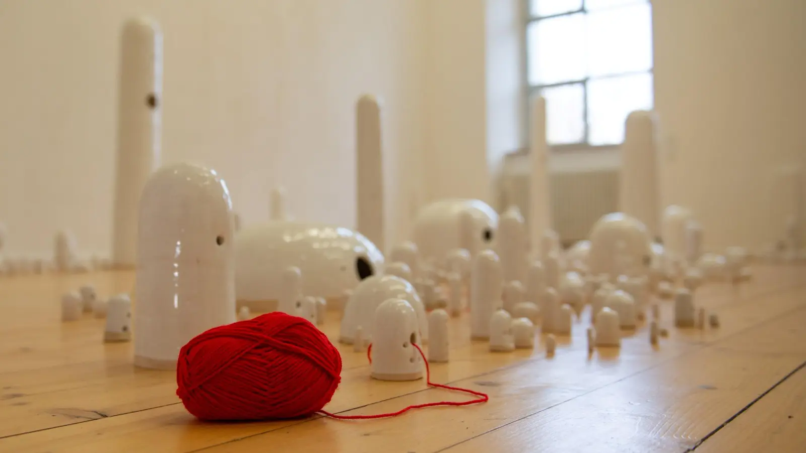 Die Installation „For You, Who Remain Within Me“ besteht aus vielen keramischen Skulpturen unterschiedlicher Größe, die über den Raum verteilt sind. (Foto: Miriam Ferstl)
