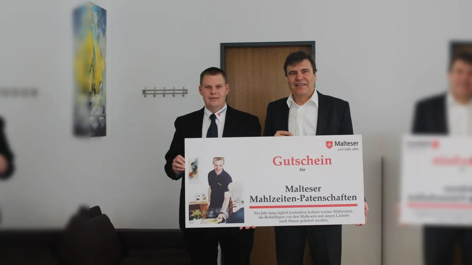 Thomas Rapp, Malteser Hilfsdienst (l.), übergibt Bürgermeister Stefan Kolbe einen Gutschein für die Mahlzeiten-Patenschaften. (Foto: KA)