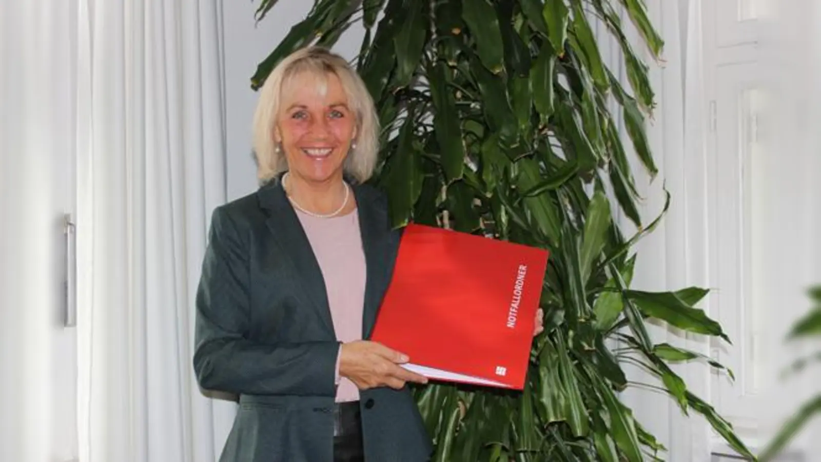 Bürgermeisterin Müller zeigt den neuen Notfallordner.  (Foto: Gemeinde Haar)