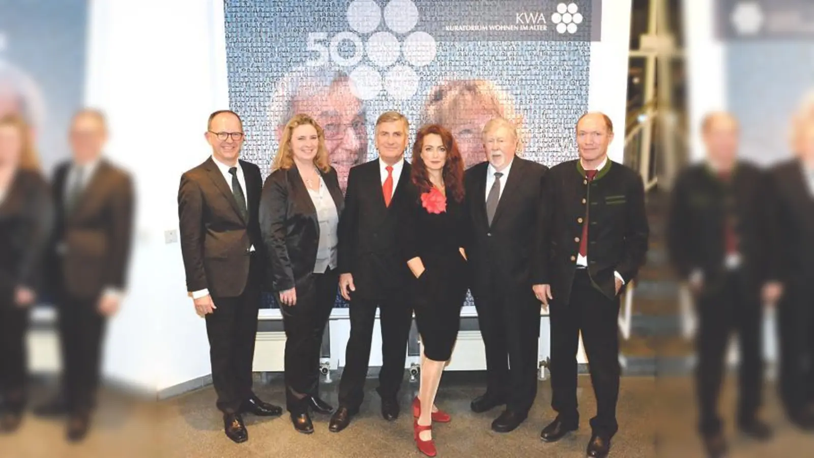 Vor dem frisch ausgerollten Banner zum Jubiläumsjahr  50 Jahre KWA, von links: Dr. Stefan Arend, Kerstin Schreyer-Stäblein, Wolf-Dieter Krause, Julia von Miller (Sängerin), Hermann Beckmann, Horst Schmieder.	 (Foto: VA)