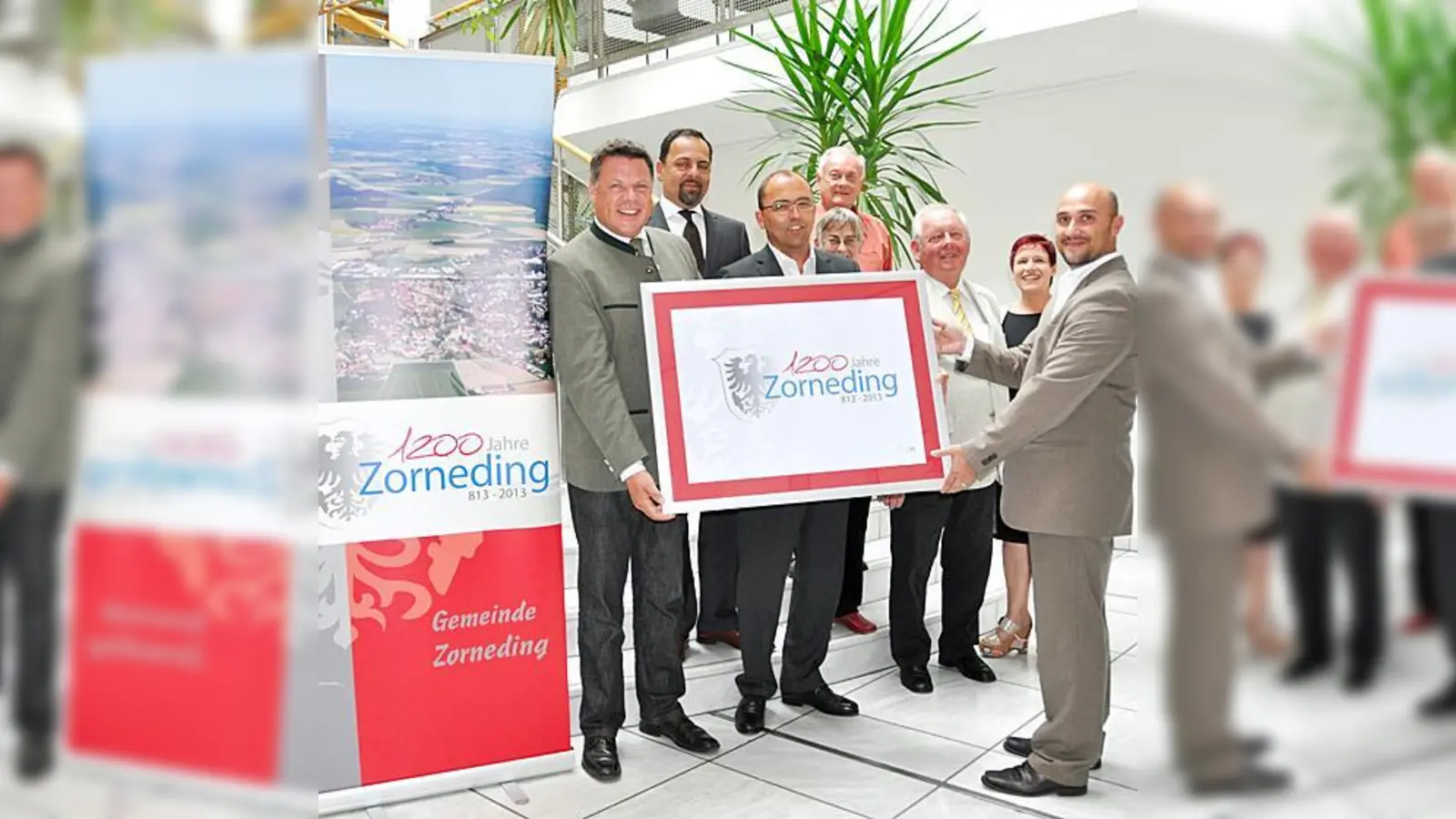 Bürgermeister Piet Mayr, Martin Bauer, Peter Ohlberger (Vorsitzender des Festausschusses), Sebastian Gruber, Emmi Heder, Franz Pfluger, Christine und Alexander Puggioni (v.l.) präsentierten am Montag das Jubiläumslogo. 	 (Foto: sf)
