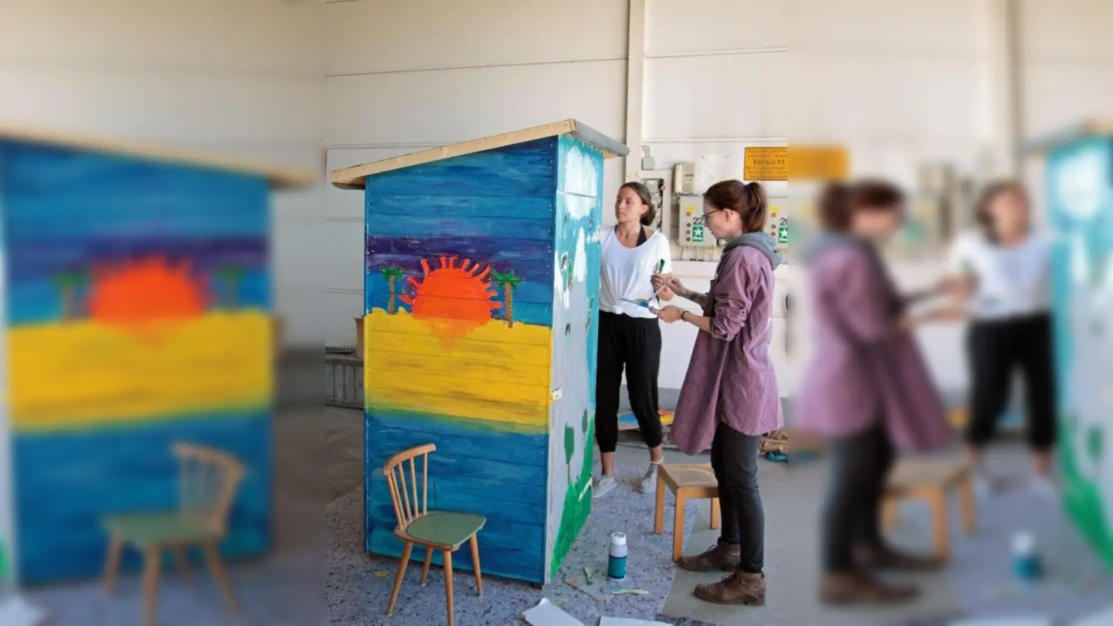 Selina Rieger (l.) und Lia Fischer bei Malarbeiten am Tauschschrank. (Foto: Gemeinde Gilching)