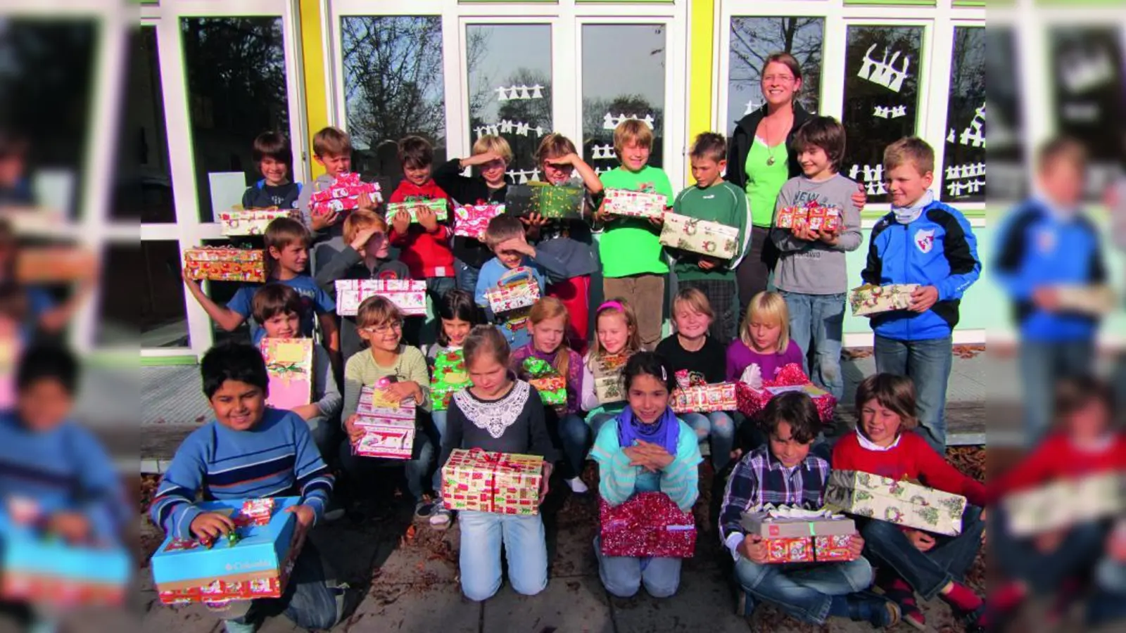 Zusammen mit ihrer Lehrerin Pia Frei präsentieren die Schüler der 3a Grundschule Eversbuschstraße stolz ihre Weihnachtsgeschenke für bedürftige Kinder. (Foto: pi)