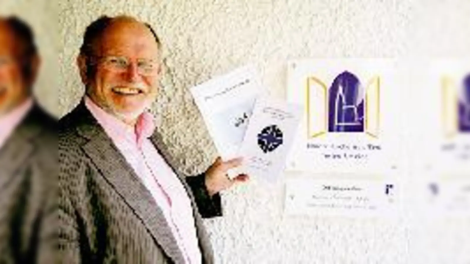 Pfarrer Norbert Greim  mit den beiden Werken zum 35. Geburtstag der Jerusalemkirchengemeinde  verweist gerne auf die ab sofort offene Kirche.  (Foto: Ka)