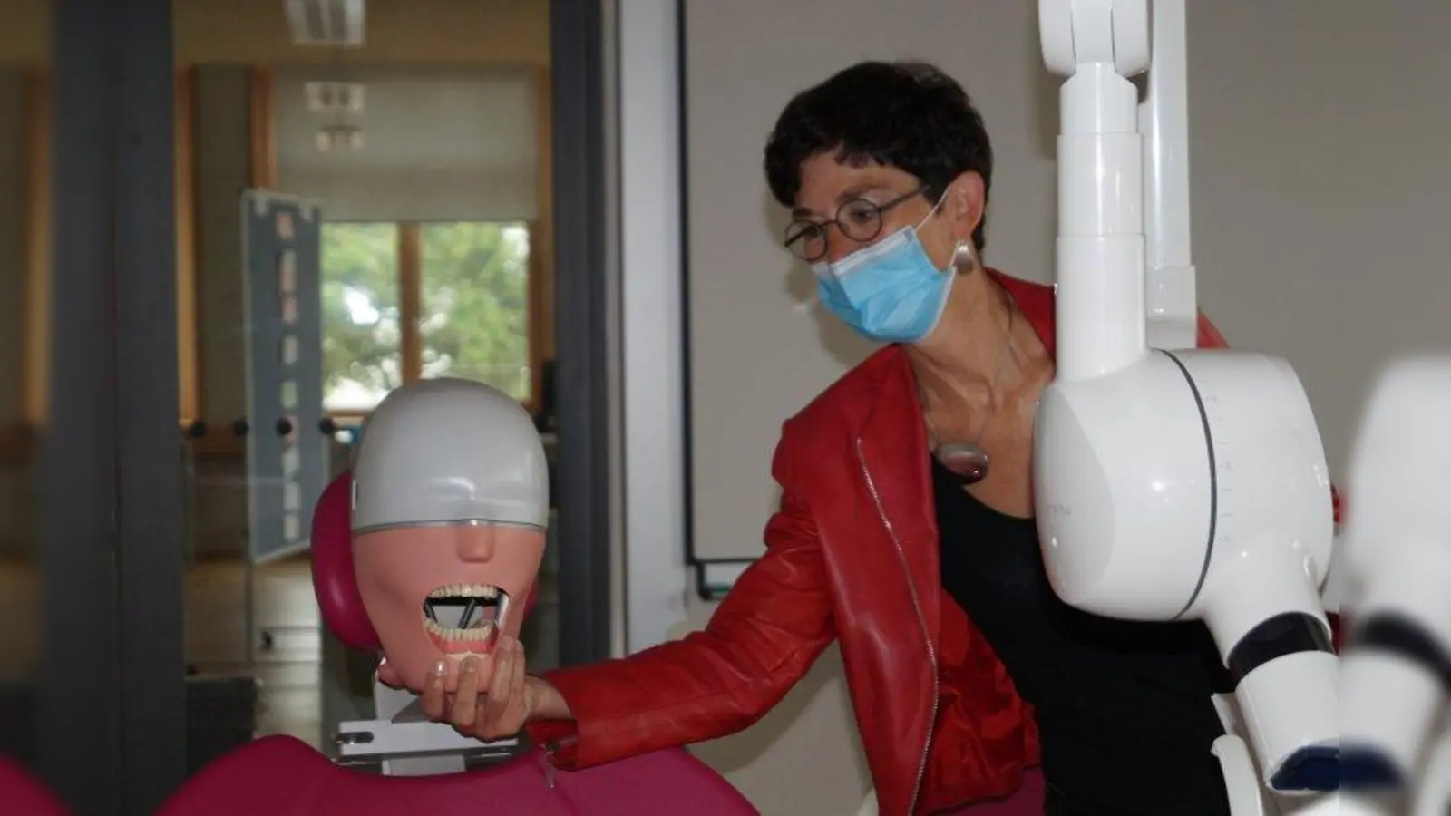 An einem echten Zahnarztstuhl mit unechtem Patienten können die Azbuis üben. Schulleiterin Andrea Reuß demonstriert den Dummy. (Foto: pst)