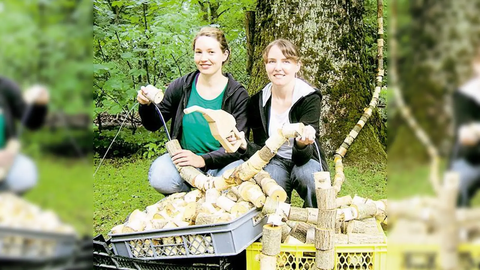 Die Holzbildhauerinnen Lisa Mayer und Julia Priss beim Aufbau des Kunstwerks »Aufgetankt«, eine hölzerne Zapfsäule mit Schlauch, die symbolisch einen Baum anzapft.   (Foto: Veranstalter)