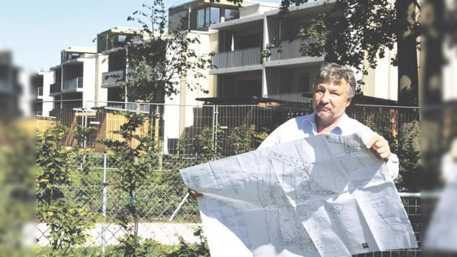 Heinz Gutbrunner mit dem aktuellen Bebauungsplan vor den Neubauten in der Maikäfersiedlung. Weitere Häuser mit Flachdach lehnt die IG ab.	 (Foto: js)