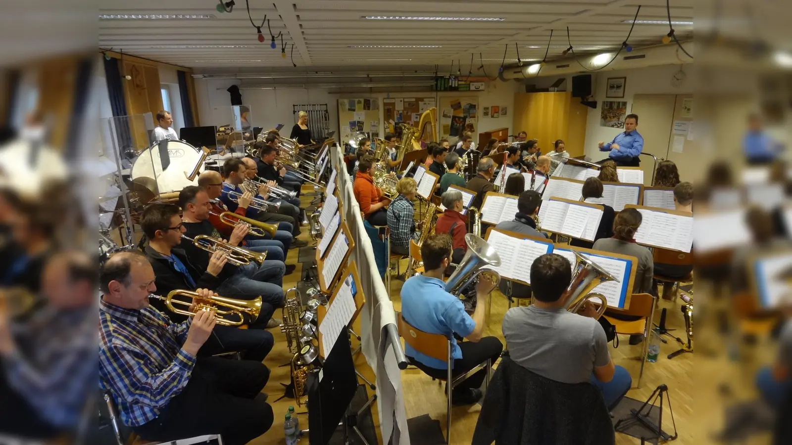 Dicht gedrängt sitzen die Musiker der vier Orchester der Blaskapelle - hier das Symphonische Blasorchester - im derzeitigen Probenraum. (Foto: VA)