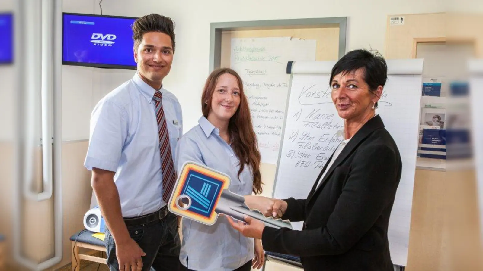 Regionalverkaufsleiterin Sabine Bader (r.) übergibt symbolisch den Schlüssel an die angehenden HandelsfachwirteThomas Alexander Fleckinger (l.) und Bianca Bornkessel (m.). (Foto: ALDI SÜD)
