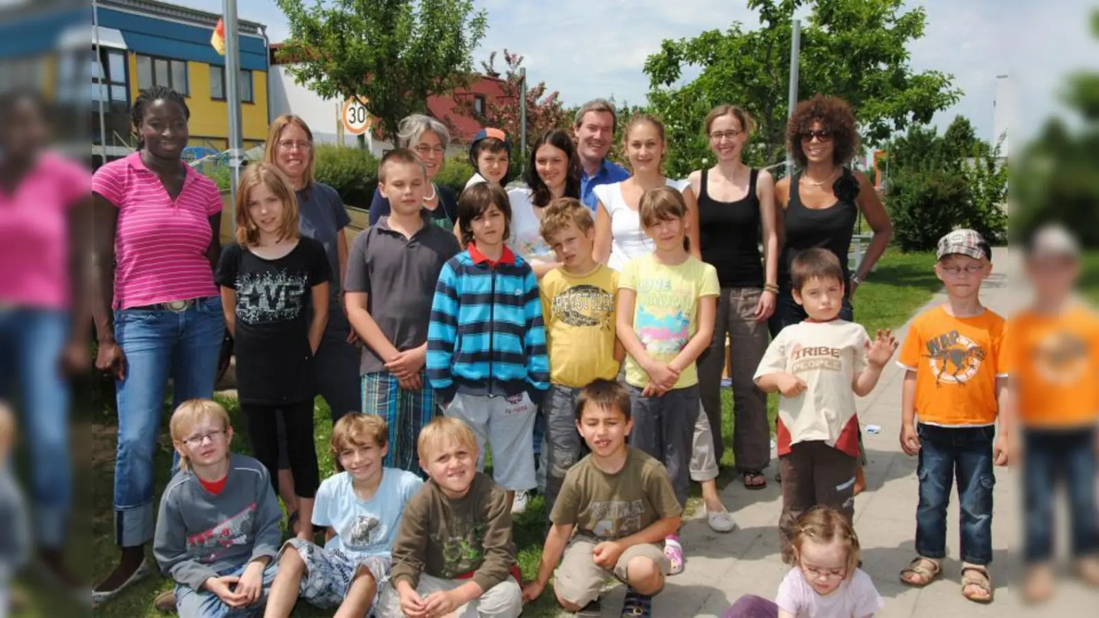 Im schön angelegten Garten des Kinderhauses Kai: Der neue Kinderhausleiter Peter Stellmach mit einigen der Kinder und etlichen der im Kinderhaus mitarbeitenden Pädagoginnen und Therapeutinnen. (Foto: Eva Schraft)