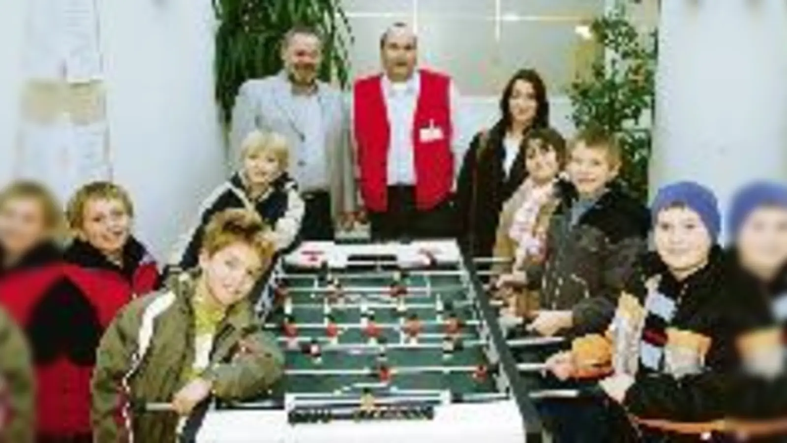 Das Christkind trägt heuer eine rote Weste: Marktleiter des Toom-Baumarktes Christoph Schietinger (hinten Mitte) übergibt den Kindern des St. Josefs-Heims ihren neuen Kicker.	  (Foto: ak)