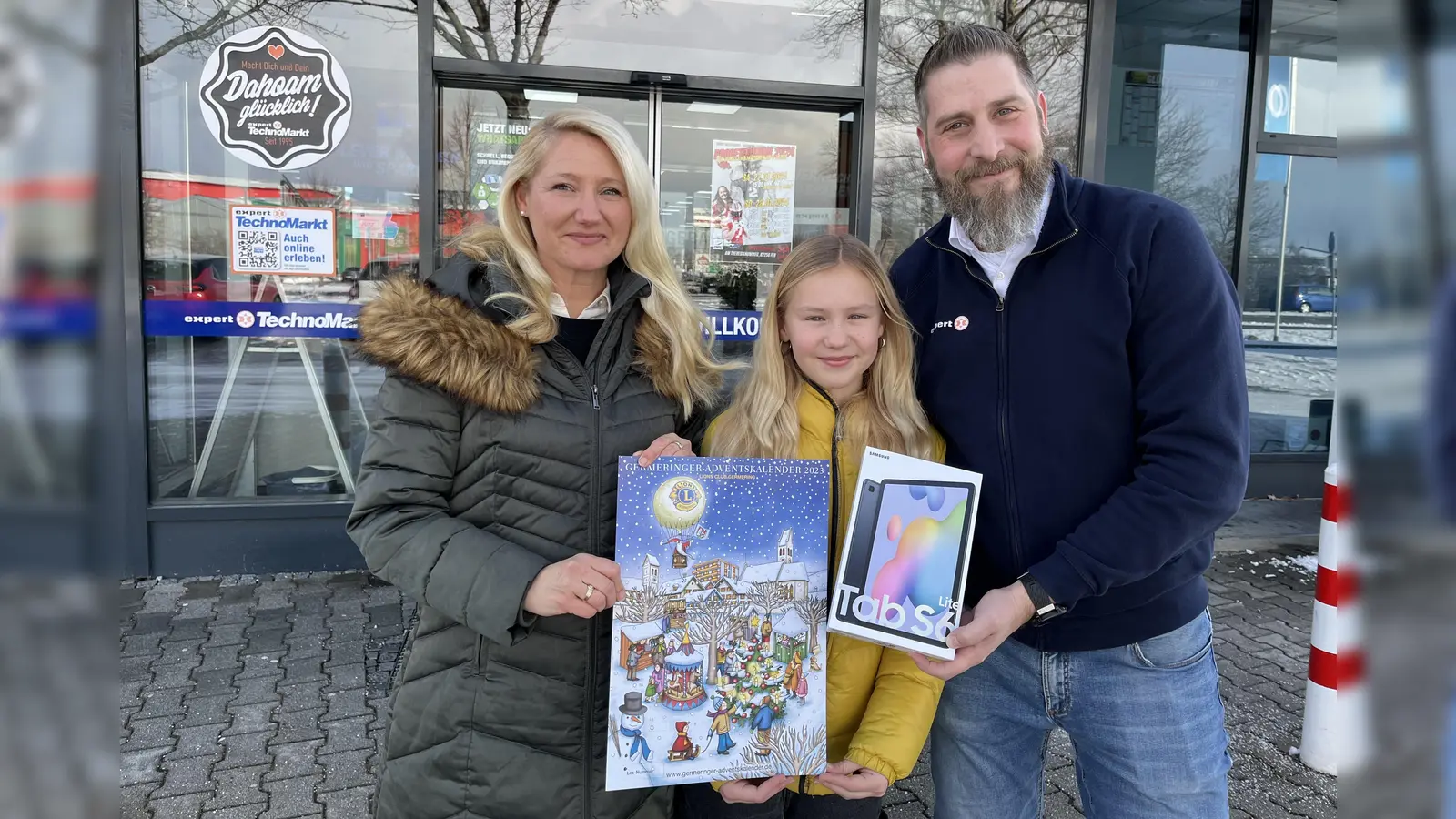 Silke Wolfenstetter und ihre Tochter freuten sich über das Tablet, das ihnen von Gerd Hübner (expert TechnoMarkt Germering) überreicht wurde. (Foto: ms)