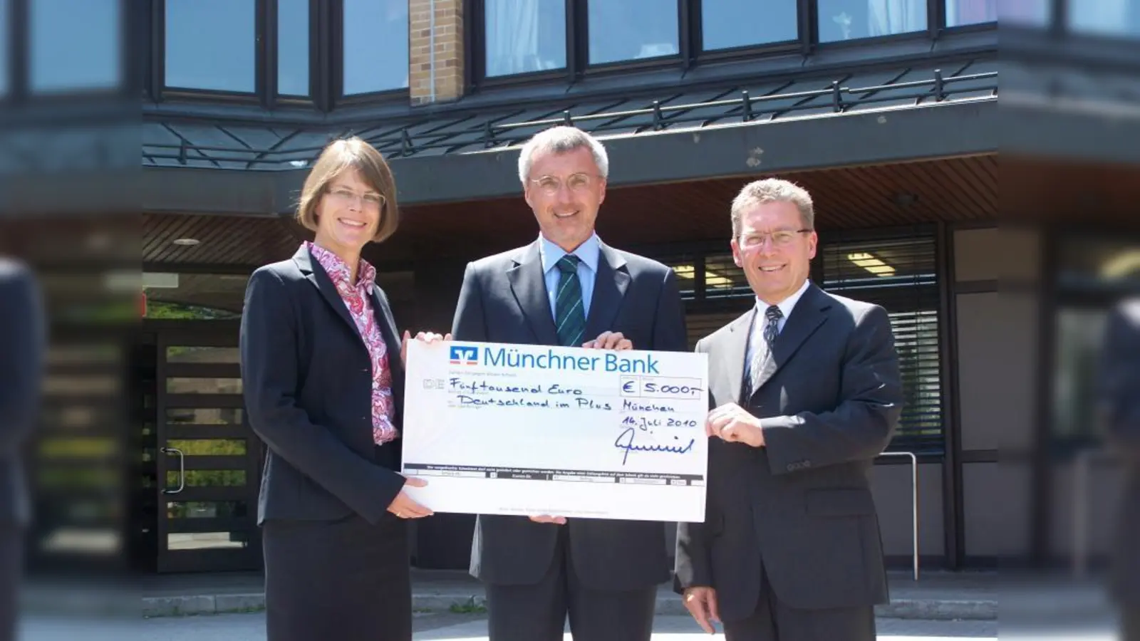 Dr. Christiane Decker (l.), Vorstandvorsitzende der Stiftung „Deutschland im Plus“, und Schulleiter Wolfgang Fladerer (M.) nehmen die Spende der Münchner Bank vom Vorstandsvorsitzenden Peter Heinrich entgegen. (Foto: pi)