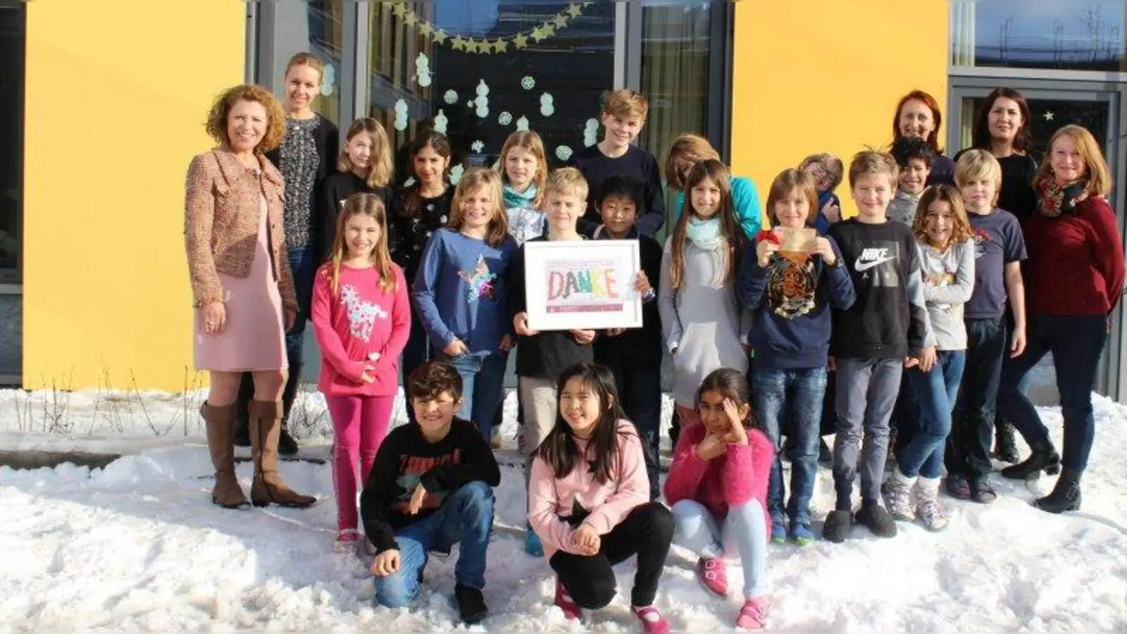 Spendenübergabe: Nina Schäfer (links), Rektorin der Grundschule in der Margarethe-Danzi-Straße, zusammen mit Johanna Funk von der „Stiftung Ambulantes Kinderhospiz” (2. von links), Lehrerin Karoline Hackner (3. von rechts), Lehrerin Doris Leschik (2. von rechts) und Sevtap Girisci vom Elternbeirat der Grundschule sowie Kindern der Grundschule. (Foto: sb)