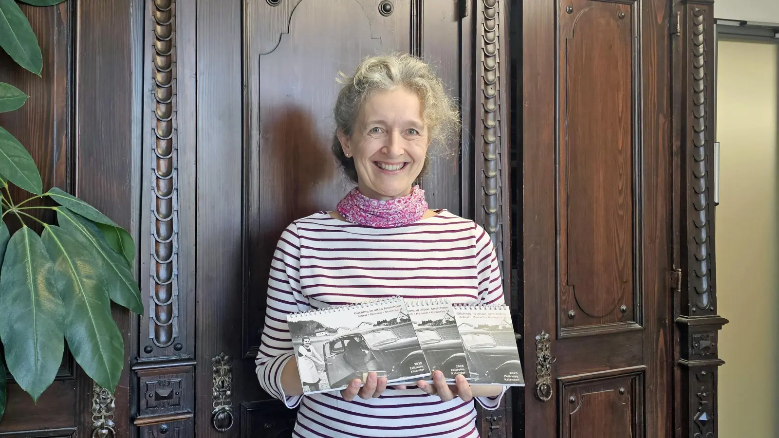 Ursula Lochner, Archivarin der Gemeinde Gilching, präsentiert den neuen Zeitreise-Kalender 2025. (Foto: Gemeinde Gilching)