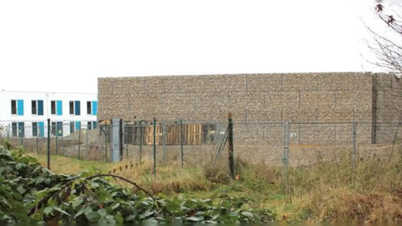 Vor allem die Dimensionierung war den Kritikern der Lärmschutzwand ein Dorn im Auge. Die Flüchtlingsunterkünfte dahinter (links im Bild) erreichen in etwa dieselbe Höhe. Das Foto entstand im November 2016.	 (Foto: Archiv/ar)