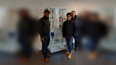 Thomas Weingärtner (hinten rechts) und die Sport-Asse Norridin und Patrick freuen sich über die Vitrine für ihre sportlichen Auszeichnungen. (Foto: Helferkreis)
