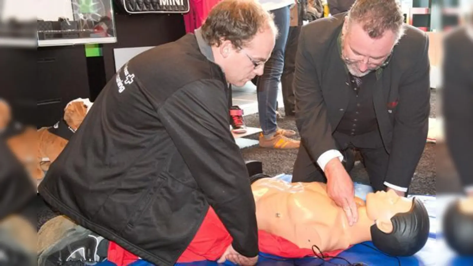 Ismanings Bürgermeister Alexander Greulich (rechts) geht mit gutem Beispiel voran und übt die Herz-Lungen-Wiederbelebung.  (Foto: Gudrun Stronsky)