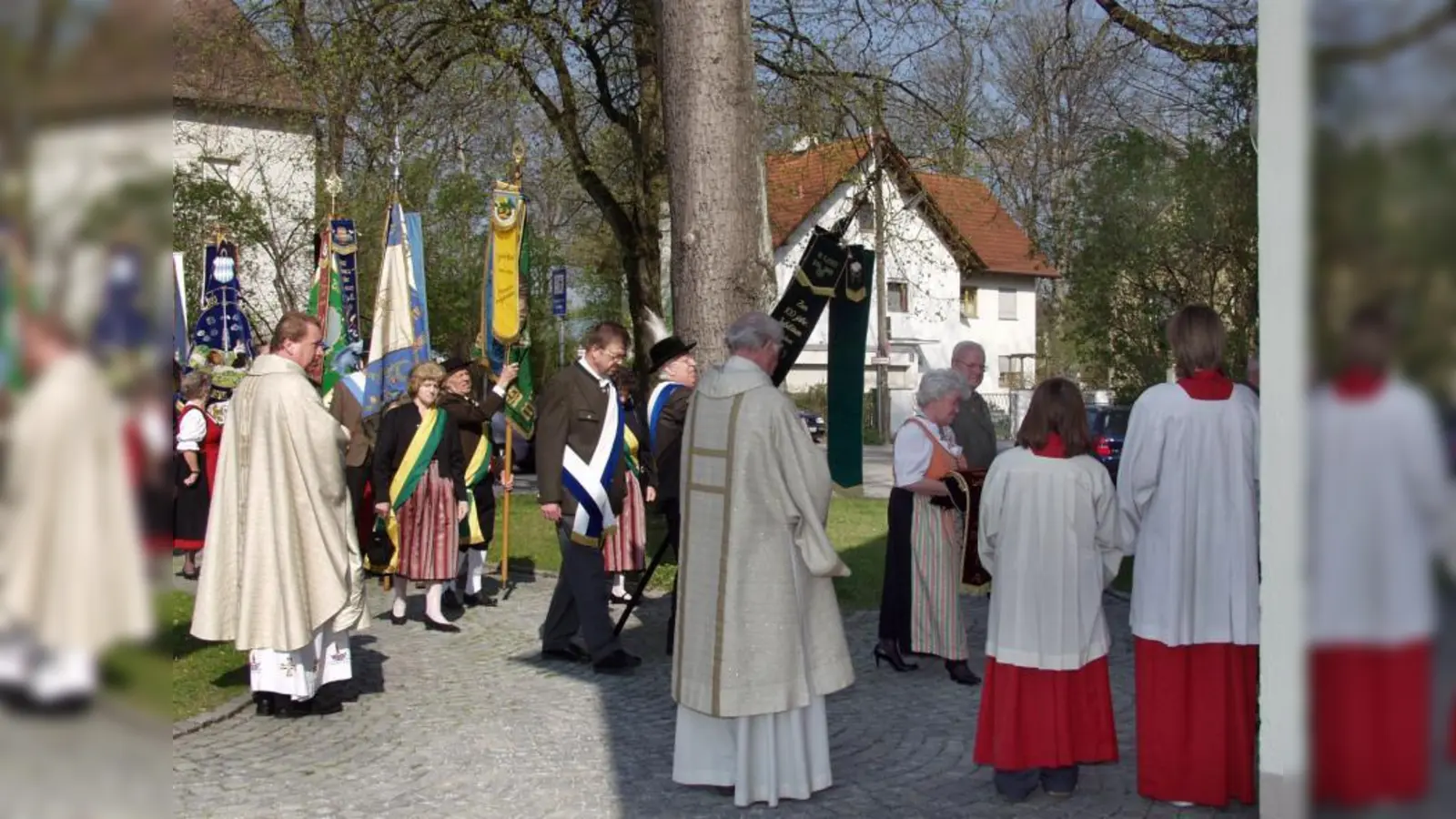 Pfarrer Jure Zirdum (l.) begrüßt die Fahnenabordnungen der Münchner Niederbayern-Vereine. (Foto: Eva Schraft)
