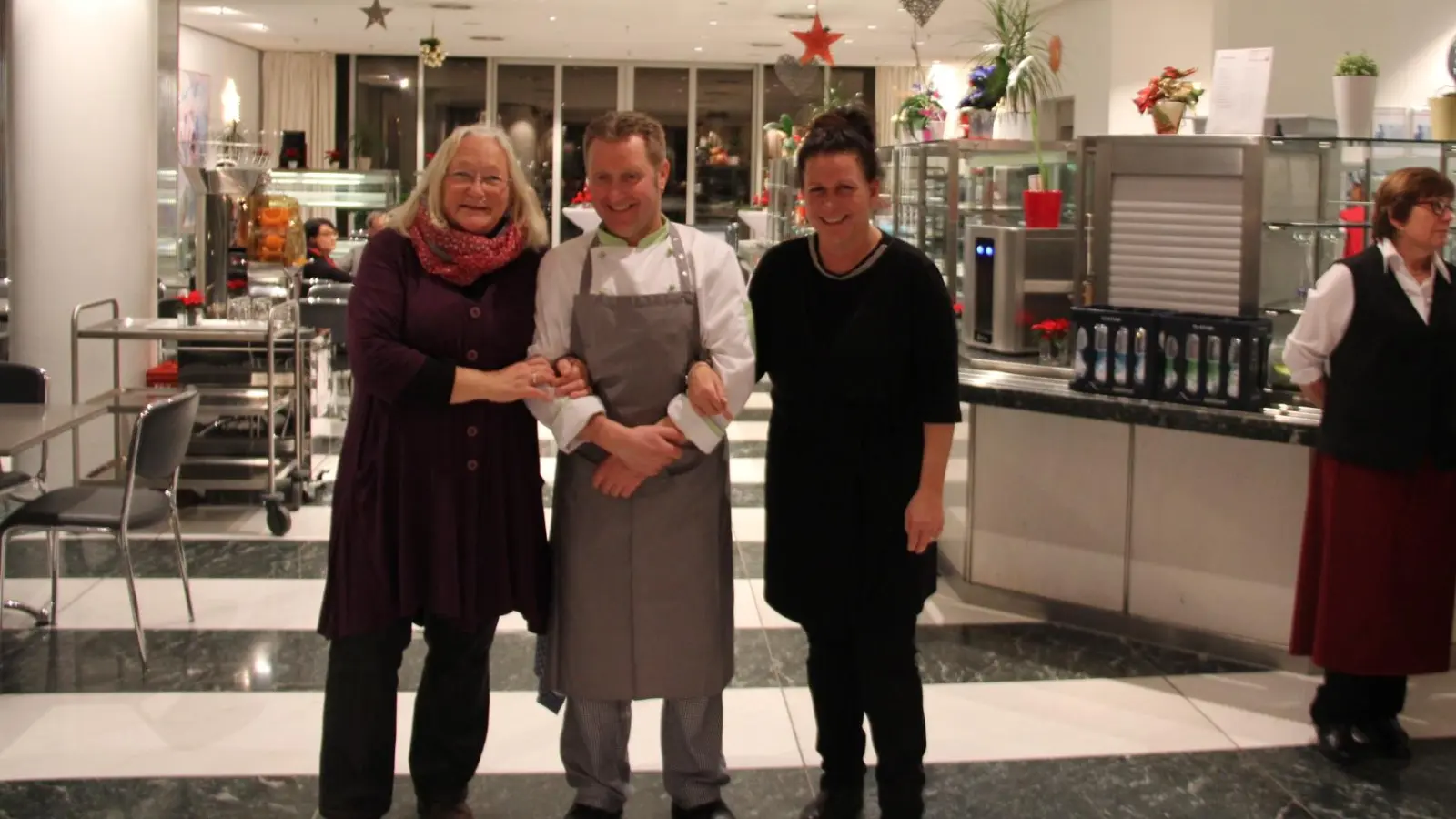 Isabel Schmidhuber (r.), ehemalige Leitung der Karla 51 und Norbert Siller, Kantinenchef der Bayer. Staatskanzlei mit Helene Nestler (l.) vor dem großen Festessen für die obdachlosen Frauen der Karla 52 (Foto: Privat)