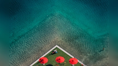 "Drei rote Sonnenschirme“ aus dem Jahr 2007 zeigt den Riemer See von oben. (Foto: 2007 Klaus Leidorf – www.Leidorf-aerial.com)
