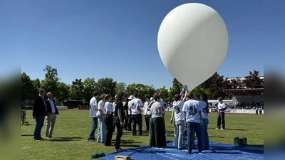 Der Stratosphären-Ballon wird von Schülern gehalten. Links: OB Andreas Haas und Schulleiter Thomas Höhenleitner. (Foto: pst)