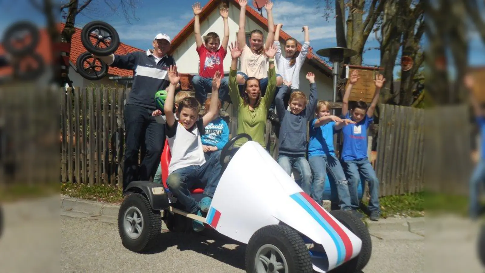 Alexander (vorne) wird in seiner Rennkiste von allen angefeuert: v.l. Organisator Andreas Heb mit Kindern der Jugend- und Kinderfeuerwehr Unterbrunn und Alexandra Heb (m.), Leiterin der Kinderfeuerwehr Unterbrunn. (Foto: © Andreas Heb)