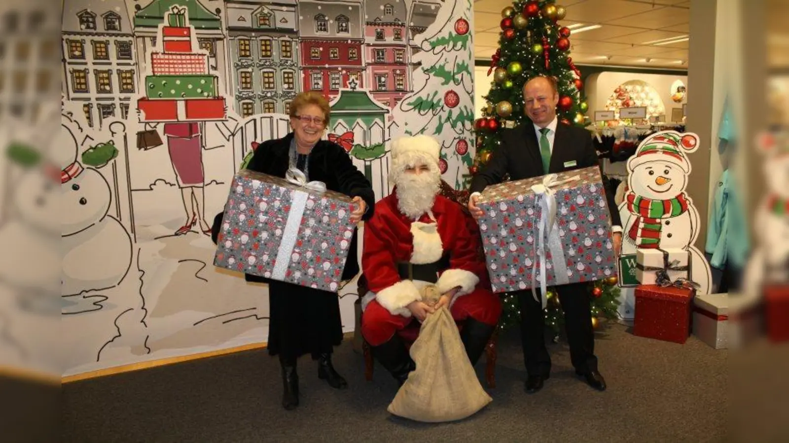 Auch der Nikolaus war da: Ingeborg Staudenmeyer, die ehemalige Vorsitzende des Bezirksausschusses Neuhausen-Nymphenburg, und Christian Lüttin, Geschäftsführer der Galeria Kaufhof am Rotkreuzplatz, präsentieren die Geschenke für den Kindergarten in der Schachenmeierstraße. (Foto: sb)