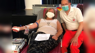 Münchens stellvertretende Landrätin Annette Ganssmüller-Maluche in Begleitung von Ismanings BRK Bereitschaftsleiter Fried Saacke beim Aderlass auf der Liege. (Foto: BRK Ismaning)