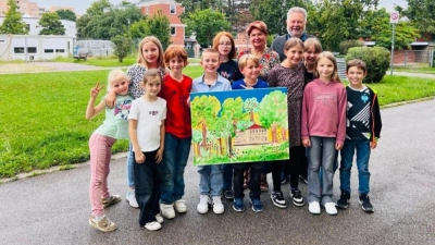 Theresia Maier und der Zweite Bürgermeister Harald Müller zeigen zusammen mit den Kindern das beim Kreativprojekt entstandene Kunstwerk.  (Foto: Theresia Maier)