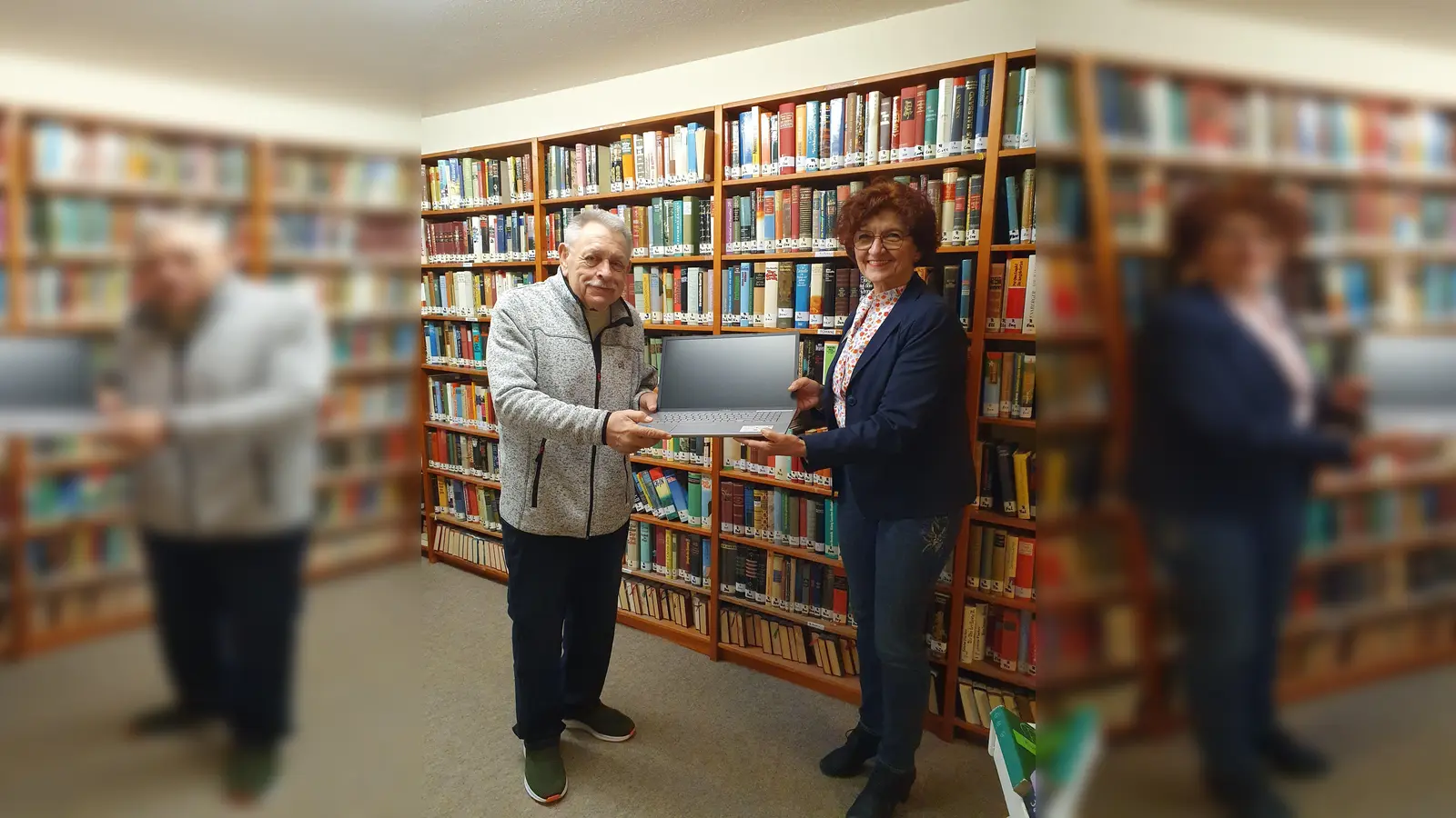 Einrichtungsleiterin Christiane Igl übergibt dem neuen Bibliothekar den Laptop. (Foto: Petra Sachs)