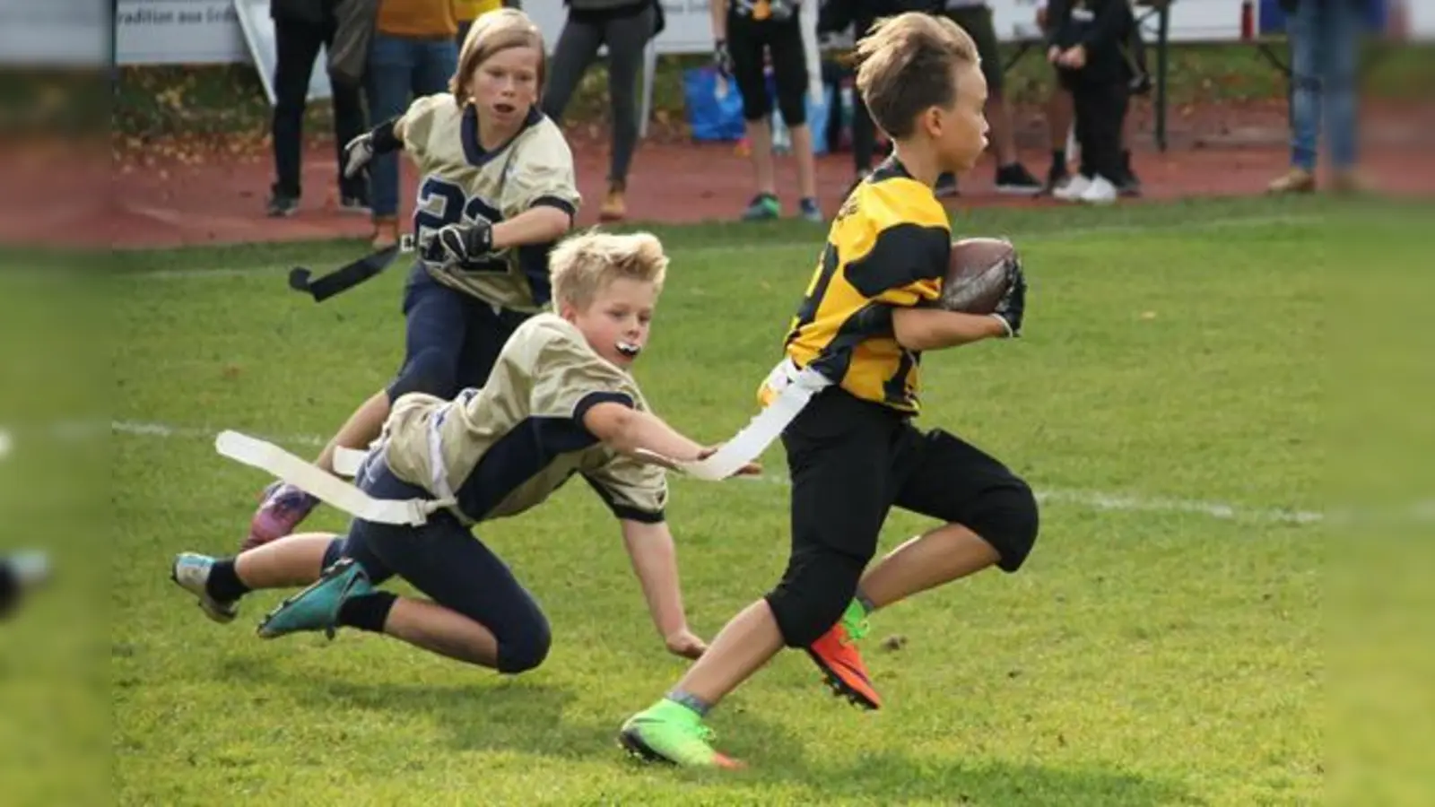 Bulls Verteidiger Fabian Lahne gibt alles, um die weiße Flag des Cowboys Angreifers zu ziehen und um ihn dadurch zu stoppen. Im Hintergrund eilt Alexander Hartl herbei, um Lahne zu unterstützen.	 (Foto: Marc Kröner)