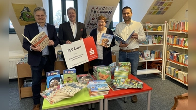 Frank Opitz (Sparkasse Fürstenfeldbruck, 2.v.l.) überbrachte den symbolischen Spendenscheck an Andrea Schlick (Büchereileiterin). Gemeinsam mit Bürgermeister Stefan Joachimsthaler (l.) und Amtsleiter Benedikt Friedinger wurden die neuen Bücherschätze begutachtet. (Foto: Gemeinde Alling)