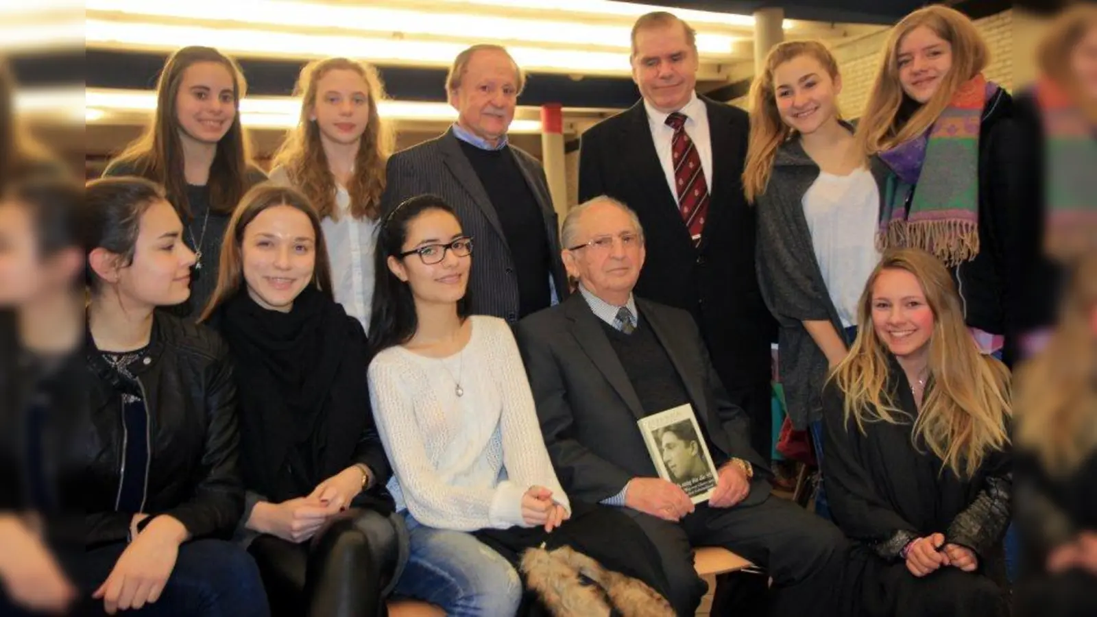 Abba Naor las im Städtischen Bert-Brecht-Gymnasium aus seinem Buch „Ich sang für die SS. Mein Weg vom Ghetto zum israelischen Geheimdienst”. Hinter ihm stehend Schulleiter Helmut Satzl und Fachbereichsleiter Karl-Jörgen Simonsen (v.r.). (Foto: us)